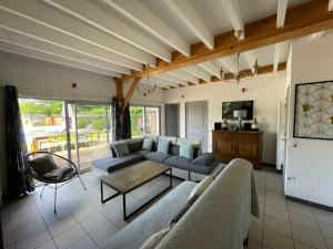 a living room with a couch and a table at Les Prairies du Val d'Amboise Grand Gite 15 pers avec piscine - PMR in Noizay