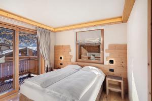 a bedroom with a bed and a large window at Livigno Wooden House in Livigno
