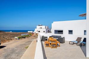 a patio with chairs and tables on a building at Kay 4 in La Santa