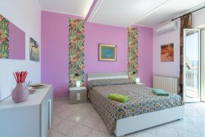 a bedroom with pink and purple walls and a bed at A Casa Mia in Floridia