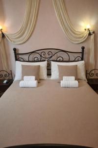 a bedroom with a large bed with two pillows at Filyra Pension in Nafplio