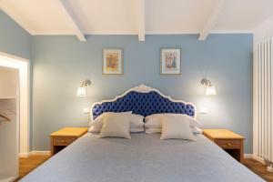 a blue bedroom with a large bed with two pillows at Bellavista Cottage in Barberino di Mugello