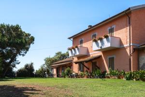 a large brick building with two balconies on a yard at Agriturismo Col Moschin in Grosseto