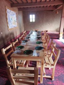 a long wooden table and chairs in a room at Dunes Activity Camp in Mhamid +59 photos