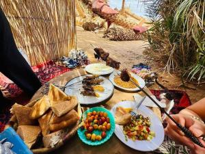 a table with plates of food on it at Dunes Activity Camp in Mhamid