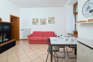 a living room with a red couch and a table at Appartamento Ania vista castello in Tenno