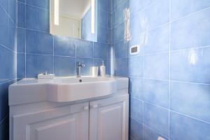 a blue tiled bathroom with a sink and a mirror at Villa Chiara in Lipari +37 photos