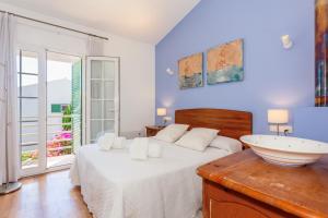a bedroom with a white bed and a sink at Aloes in Sa Caleta