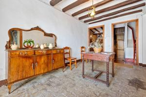 a room with a wooden dresser and a mirror at Ca Cedó in Serra de Almós