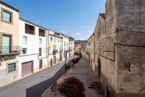 an empty street in an alley with buildings at Ca Cedó in Serra de Almós