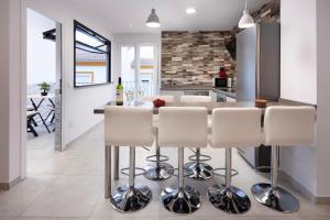 a kitchen with a bar with white stools at El Monte in Cómpeta +15 photos