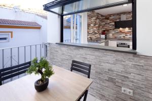 a balcony with a wooden table and a potted plant at El Monte in Cómpeta