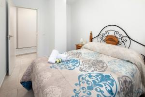 a bedroom with a bed with a blue and white blanket at El Monte in Cómpeta
