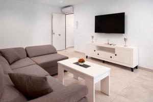 a living room with a couch and a tv at El Monte in Cómpeta