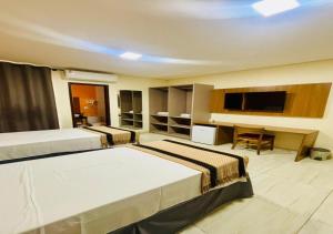 a hotel room with two beds and a flat screen tv at Boulevard Park Hotel in São Luís