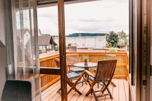 a patio with a table and chairs on a balcony at Ferienwohnung Alte Schneiderei in Heideck