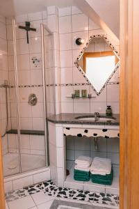 a bathroom with a shower and a sink with towels at Ferienwohnung Alte Schneiderei in Heideck +27 photos
