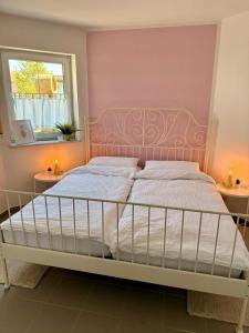 a bedroom with a bed with a pink wall at Lieblingszeit bei Bamberg in Hirschaid
