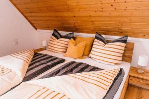 a bedroom with two beds with pillows at Ferienwohnung Alte Schneiderei in Heideck