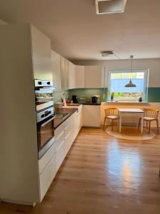 a kitchen with white cabinets and a table with chairs at Lieblingszeit bei Bamberg in Hirschaid