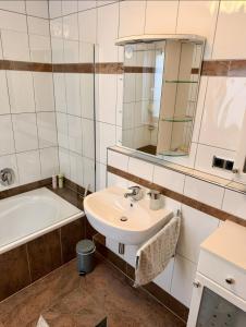 a bathroom with a sink and a tub and a mirror at Lieblingszeit bei Bamberg in Hirschaid