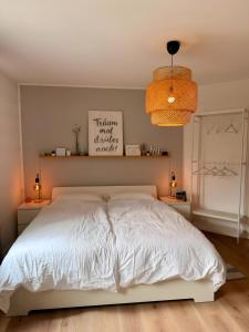a bedroom with a white bed and two night stands at Lieblingszeit bei Bamberg in Hirschaid +5 photos