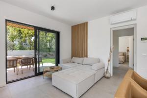 a living room with a white couch and a table at Villa Luma with private Pool in Lazise