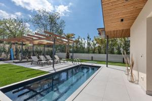 a swimming pool in a backyard with a patio furniture and a house at Villa Luma with private Pool in Lazise