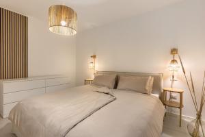 a white bedroom with a bed and two lamps at Villa Luma with private Pool in Lazise +25 photos