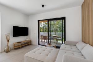 a living room with a white couch and a tv at Villa Luma with private Pool in Lazise