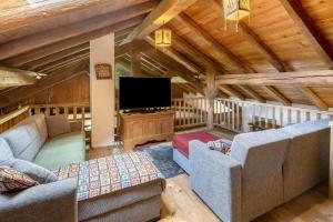 a living room with two couches and a flat screen tv at Chalet El Deroch - Bellamonte in Bellamonte