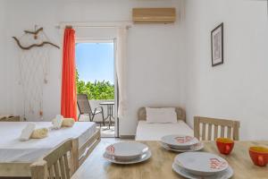 a room with two beds and a table with plates on it at Perasma Studio 5 in Kipri