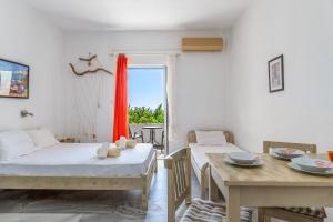 a room with two beds and a table and a window at Perasma Studio 5 in Kipri