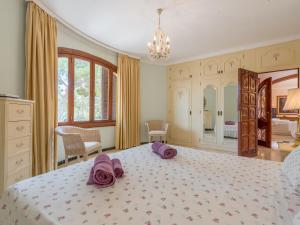 a bedroom with a large bed with purple towels on it at Villa Torre in Cala Santanyi +21 photos
