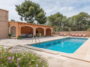 an outdoor swimming pool with a patio and a house at Villa Torre in Cala Santanyi