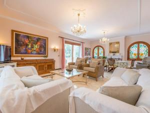 a living room with white furniture and a chandelier at Villa Torre in Cala Santanyi