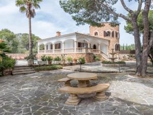 an exterior view of a house with a table in front of it at Villa Torre in Cala Santanyi