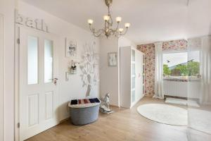 a white room with a door and a chandelier at Ferienwohnung Am Jakobsweg in Schmallenberg +18 photos