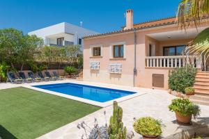 a villa with a swimming pool and a house at Can Fiol in Portocolom