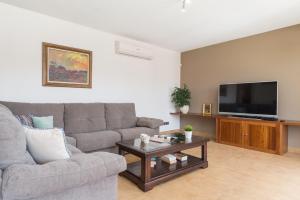 a living room with a couch and a tv at Can Fiol in Portocolom