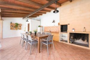 a kitchen and dining room with a wooden table and chairs at Can Fiol in Portocolom
