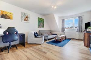 ein Wohnzimmer mit Sofa und Sessel in der Unterkunft Rode in Faßberg
