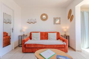 a living room with an orange couch and a table at Azur et Lavande proche plage in Fréjus