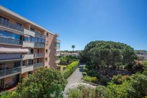 an apartment building with a garden and trees at Azur et Lavande proche plage in Fréjus