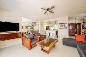 a living room with a flat screen tv and a table at Oceanfront home with beach access pool balconies & waterfront hammocks - Villa Sol in Tulum