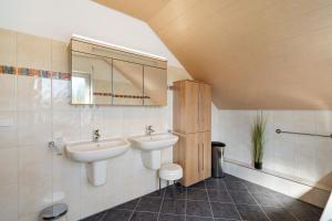 a bathroom with two sinks and a mirror at Haus Langer in Oberkirch +25 photos