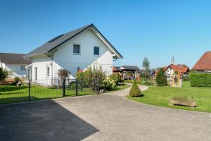 a white house with a fence in a yard at Haus Langer in Oberkirch