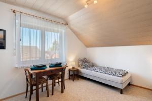 a bedroom with a bed and a desk and a window at Haus Langer in Oberkirch