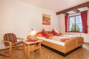 a bedroom with a bed and a chair at Ferienwohnung Risthof 1 in Owingen