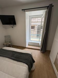 a bedroom with a bed and a large window at Rincon del puerto I in A Guarda